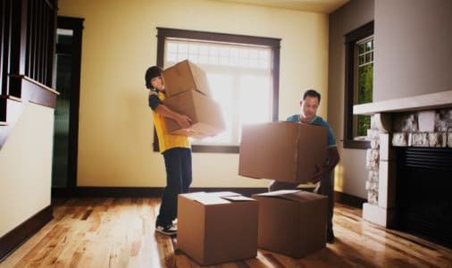 Un père et son fils qui transportent des cartons pendant leur déménagement